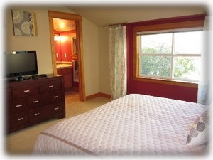 Master bedroom with king bed, TV and attached bathroom